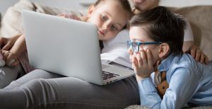 Mum and 2 kids watching a movie on a laptop
