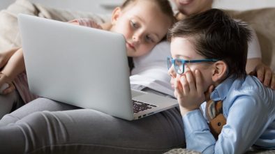 Mum and 2 kids watching a movie on a laptop
